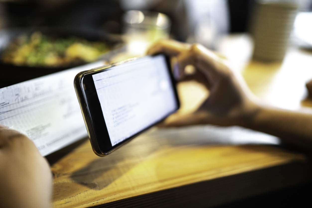 Person holding a phone taking a photo of a check